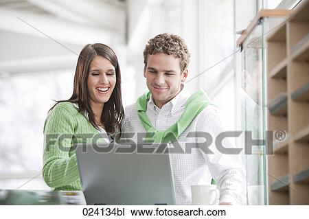 Stock Image - portrait of young businesswoman and male colleague looking at computer. Fotosearch