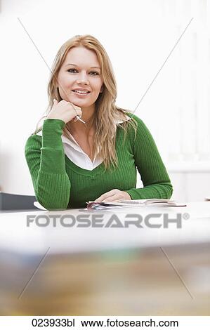 Stock Image - portrait of young businesswoman at desk. Fotosearch