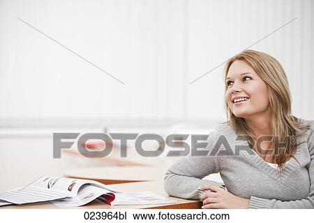 Stock Image - portrait of young businesswoman at desk. Fotosearch