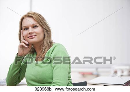 Stock Image - portrait of young businesswoman at desk. Fotosearch