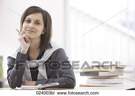 Stock Image - portrait of young businesswoman at desk. Fotosearch