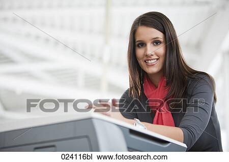 Stock Image - portrait of young businesswoman at photocopier. Fotosearch