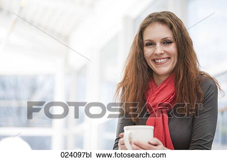 Stock Image - portrait of young businesswoman holding cup. Fotosearch