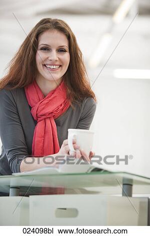 Stock Image - portrait of young businesswoman holding cup. Fotosearch