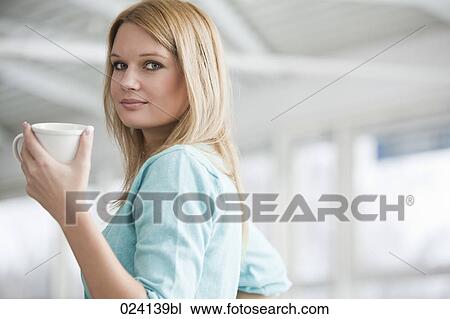 Stock Image - portrait of young businesswoman holding cup. Fotosearch