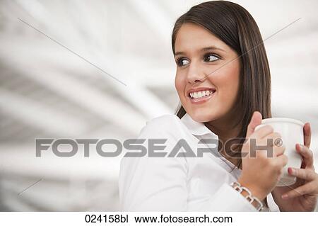 Stock Image - portrait of young businesswoman holding cup. Fotosearch