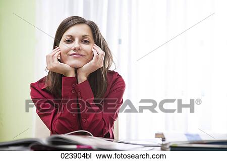 portrait of young businesswoman sitting at desk View Large Photo Image Stock Image - portrait of young businesswoman sitting at desk. Fotosearch