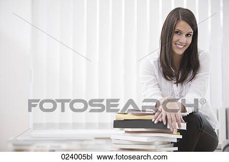portrait of young businesswoman sitting on desk View Large Photo Image Stock Image - portrait of young businesswoman sitting on desk. Fotosearch