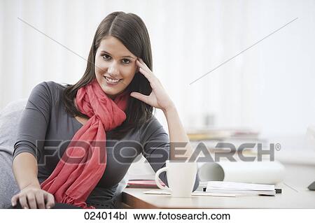 portrait of young businesswoman sitting at desk with cup View Large Photo Image Stock Image - portrait of young businesswoman sitting at desk with cup. Fotosearch
