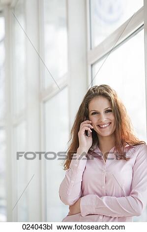 Stock Image - portrait of young businesswoman talking on mobile phone. Fotosearch