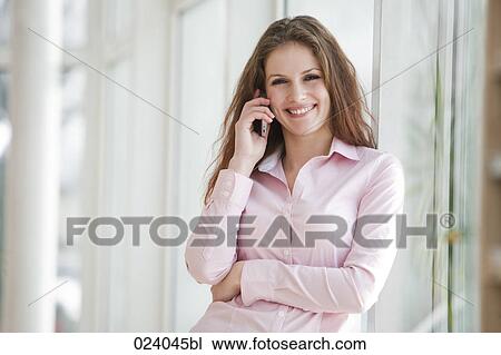 Stock Image - portrait of young businesswoman talking on mobile phone. Fotosearch