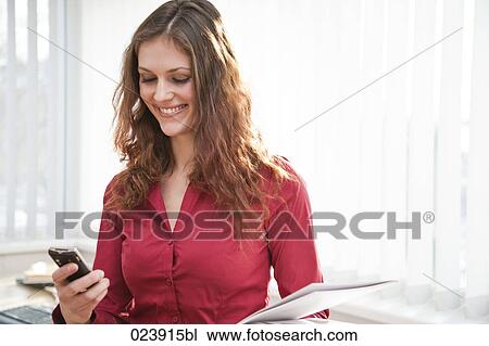 Stock Image - portrait of young businesswoman with mobile phone. Fotosearch