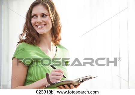 Stock Image - portrait of young businesswoman with diary. Fotosearch