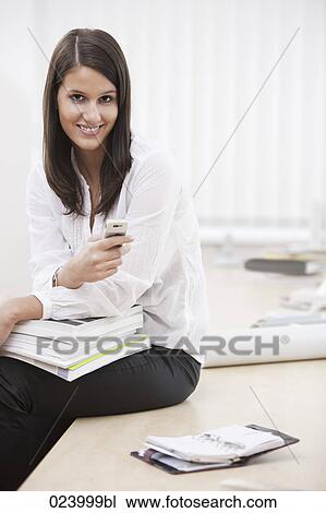 Stock Image - portrait of young businesswoman with mobile phone. Fotosearch