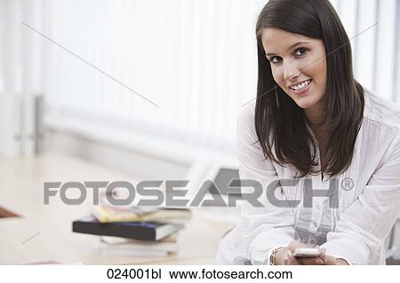 Stock Image - portrait of young businesswoman with mobile phone. Fotosearch