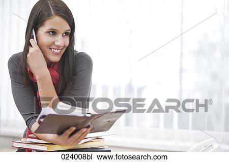 Stock Image - portrait of young businesswoman with diary and mobile phone. Fotosearch