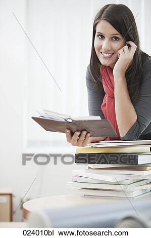 Stock Image - portrait of young businesswoman with diary and mobile phone. Fotosearch
