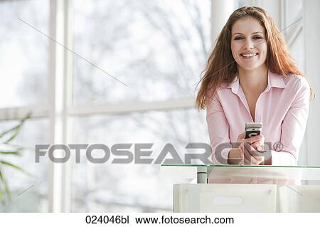 Stock Image - portrait of young businesswoman with mobile phone. Fotosearch