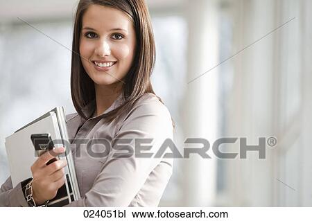 Stock Image - portrait of young businesswoman with documents and mobile phone. Fotosearch