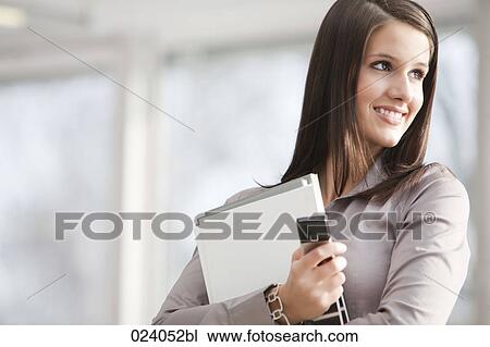 Stock Image - portrait of young businesswoman with documents and mobile phone. Fotosearch