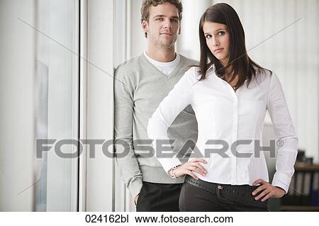Stock Image - portrait of young businesswoman with male colleague. Fotosearch