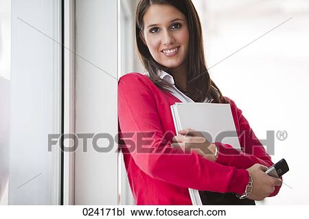 Stock Image - portrait of young businesswoman with documents and mobile phone. Fotosearch