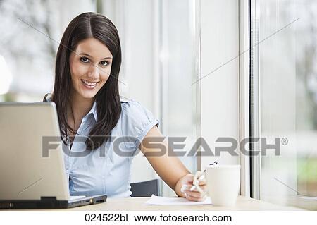 Stock Image - portrait of young businesswoman working with laptop computer. Fotosearch