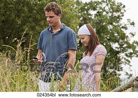 portrait of young couple checking their mobile phones for text messages View Large Photo Image Stock Image - portrait of young couple checking their mobile phones for text messages. Fotosearch