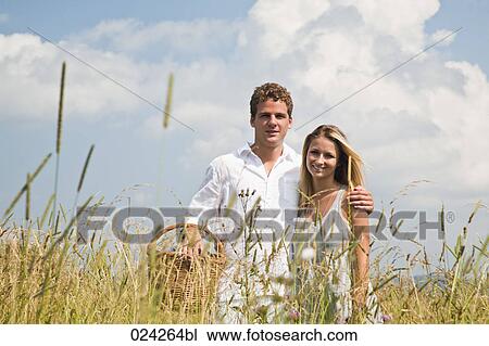 Stock Image - portrait of young couple in field. Fotosearch