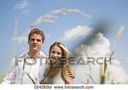 Stock Image - portrait of young couple in field. Fotosearch