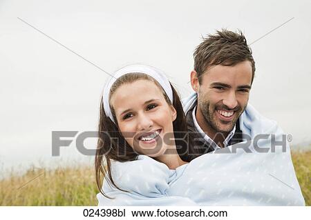 portrait of young couple outdoors wrapped in a blanket View Large Photo Image Stock Image - portrait of young couple outdoors wrapped in a blanket. Fotosearch