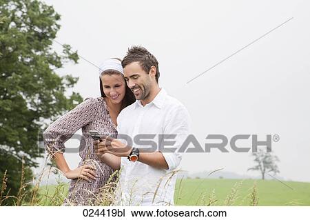 portrait of young couple reading message on mobile phone View Large Photo Image Stock Image - portrait of young couple reading message on mobile phone. Fotosearch