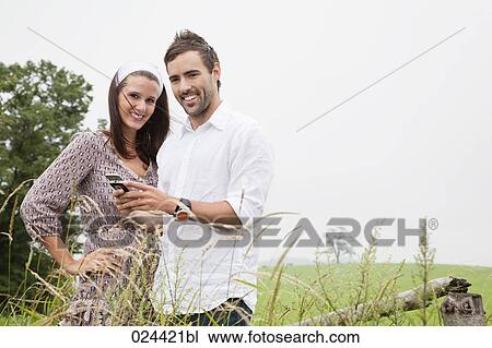 portrait of young couple reading message on mobile phone View Large Photo Image Stock Image - portrait of young couple reading message on mobile phone. Fotosearch