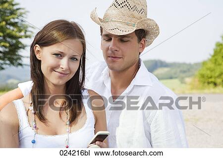 Stock Image - portrait of young couple with mobile phone. Fotosearch