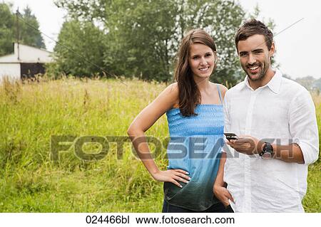 Stock Image - portrait of young couple with mobile phone. Fotosearch