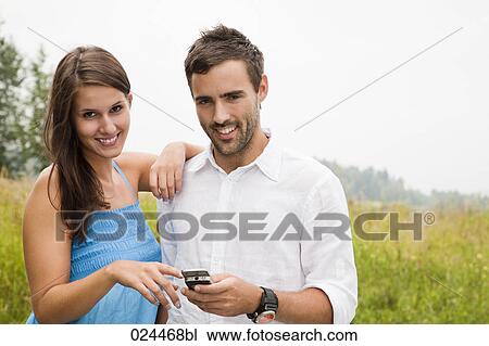 Stock Image - portrait of young couple with mobile phone. Fotosearch
