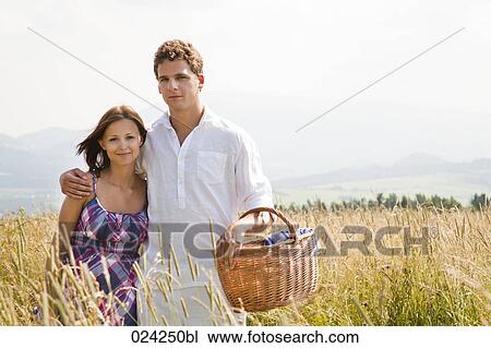 portrait of young couple with picnic basket in field View Large Photo Image Stock Image - portrait of young couple with picnic basket in field. Fotosearch