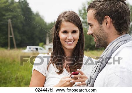Stock Image - portrait of young couple woman eith mobile phone. Fotosearch