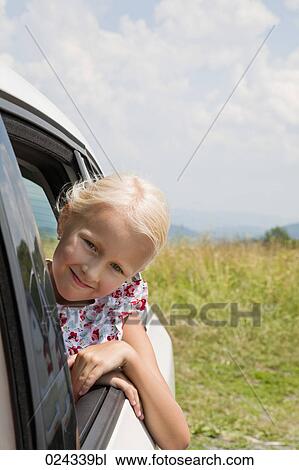 Stock Image - portrait of young girl looking out of car window. Fotosearch