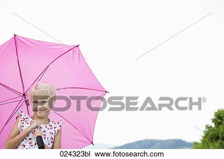 Stock Image - portrait of young girl with pink umbrella. Fotosearch