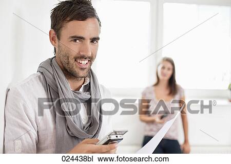 portrait of young man in empty room with mobile phone View Large Photo Image Stock Image - portrait of young man in empty room with mobile phone. Fotosearch