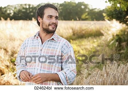 portrait of young man in font of field View Large Photo Image Stock Image - portrait of young man in font of field. Fotosearch
