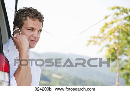 portrait of young man in trunk of car with mobile phone View Large Photo Image Stock Image - portrait of young man in trunk of car with mobile phone. Fotosearch