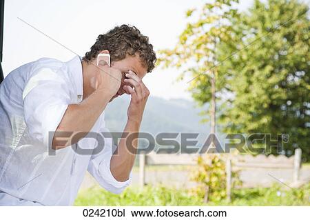 Stock Image - portrait of young man in trunk of car with mobile phone. Fotosearch