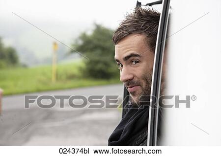 portrait of young man looking out of car window View Large Photo Image Stock Image - portrait of young man looking out of car window. Fotosearch