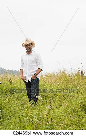 portrait of young man standing in meadow View Large Photo Image Stock Image - portrait of young man standing in meadow. Fotosearch