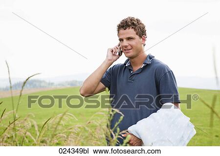 Stock Image - portrait of young man talking on mobile phone. Fotosearch