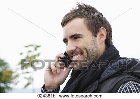Stock Image - portrait of young man talking on mobile phone. Fotosearch