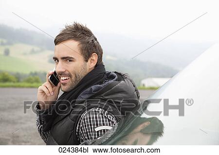 Stock Image - portrait of young man talking on mobile phone. Fotosearch