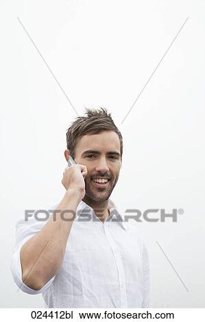 Stock Image - portrait of young man talking on mobile phone. Fotosearch
